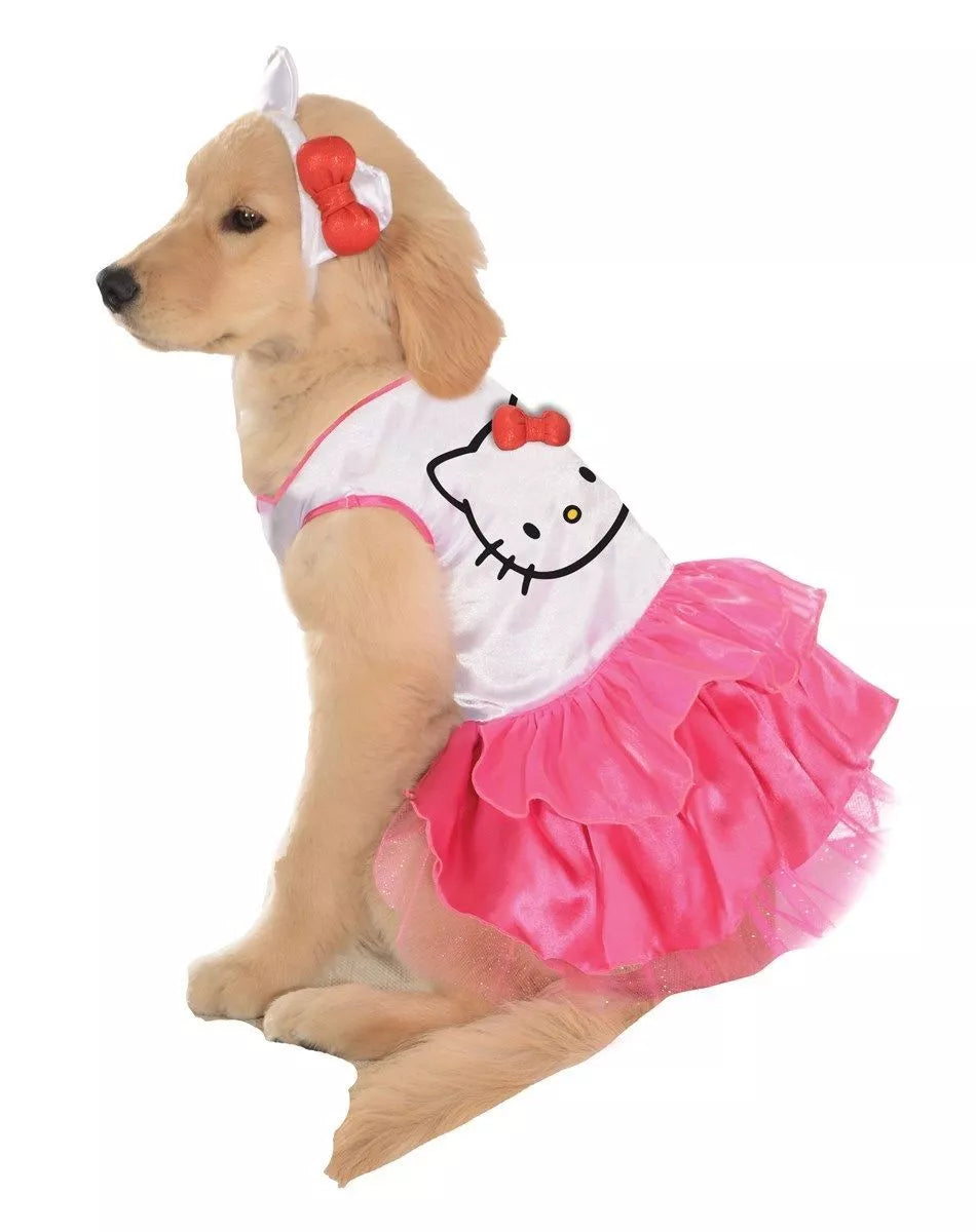 Adorable golden retriever puppy in a Hello Kitty dog dress with a pink ruffled skirt and matching bow headband