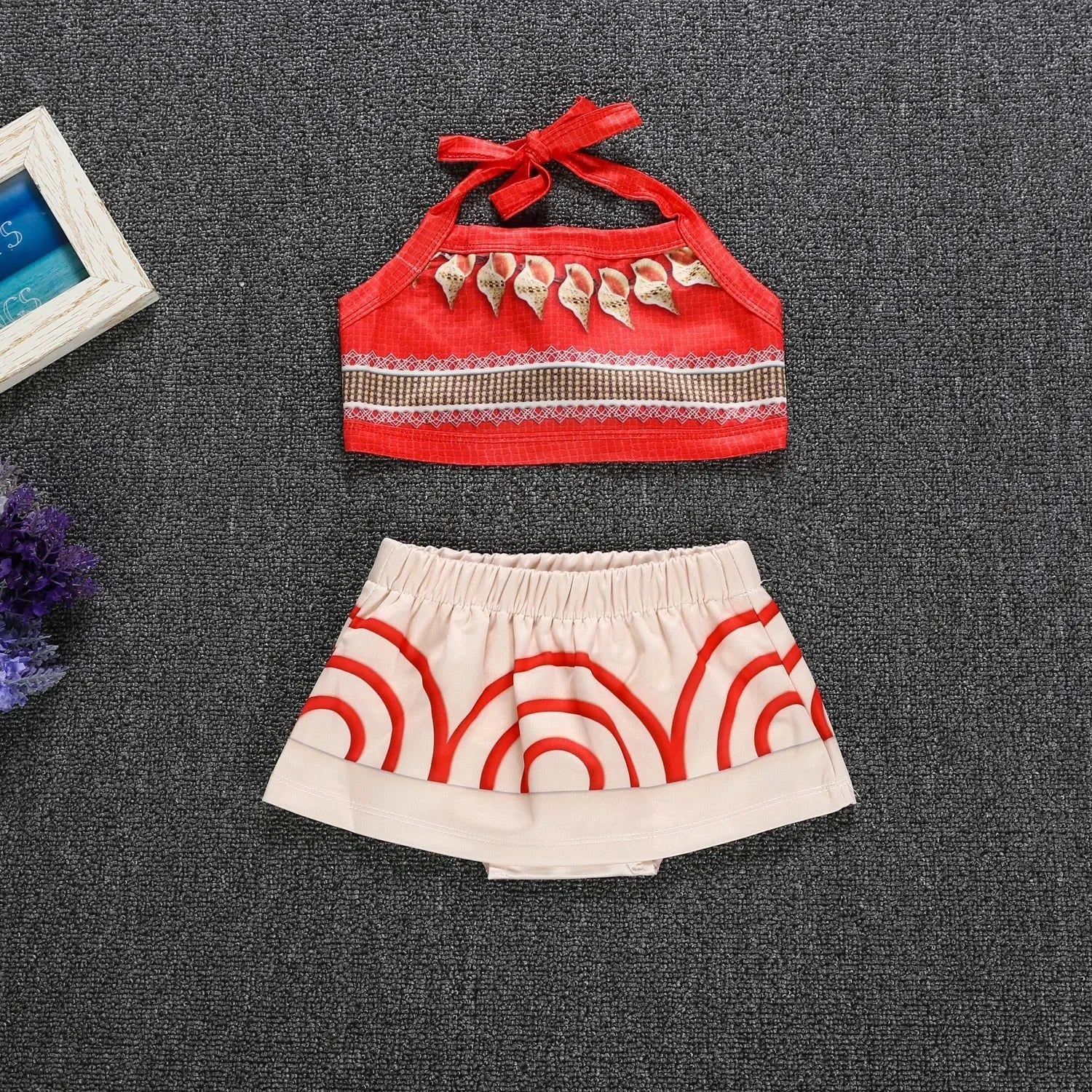 Moana costume for little girls featuring a red top and white skirt with red circular patterns