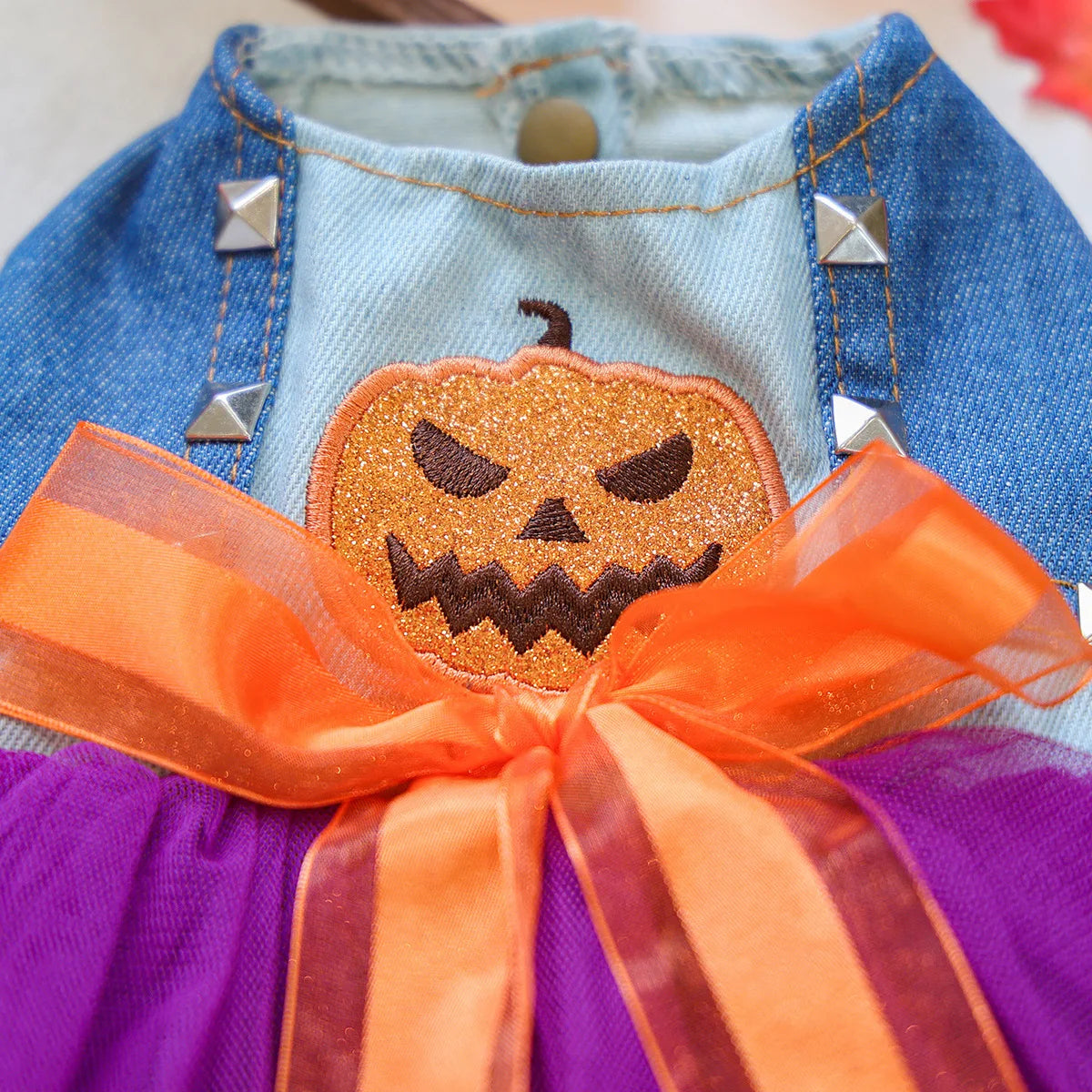Cute Halloween pumpkin skirt for pets with denim top and orange bow, featuring a spooky pumpkin design