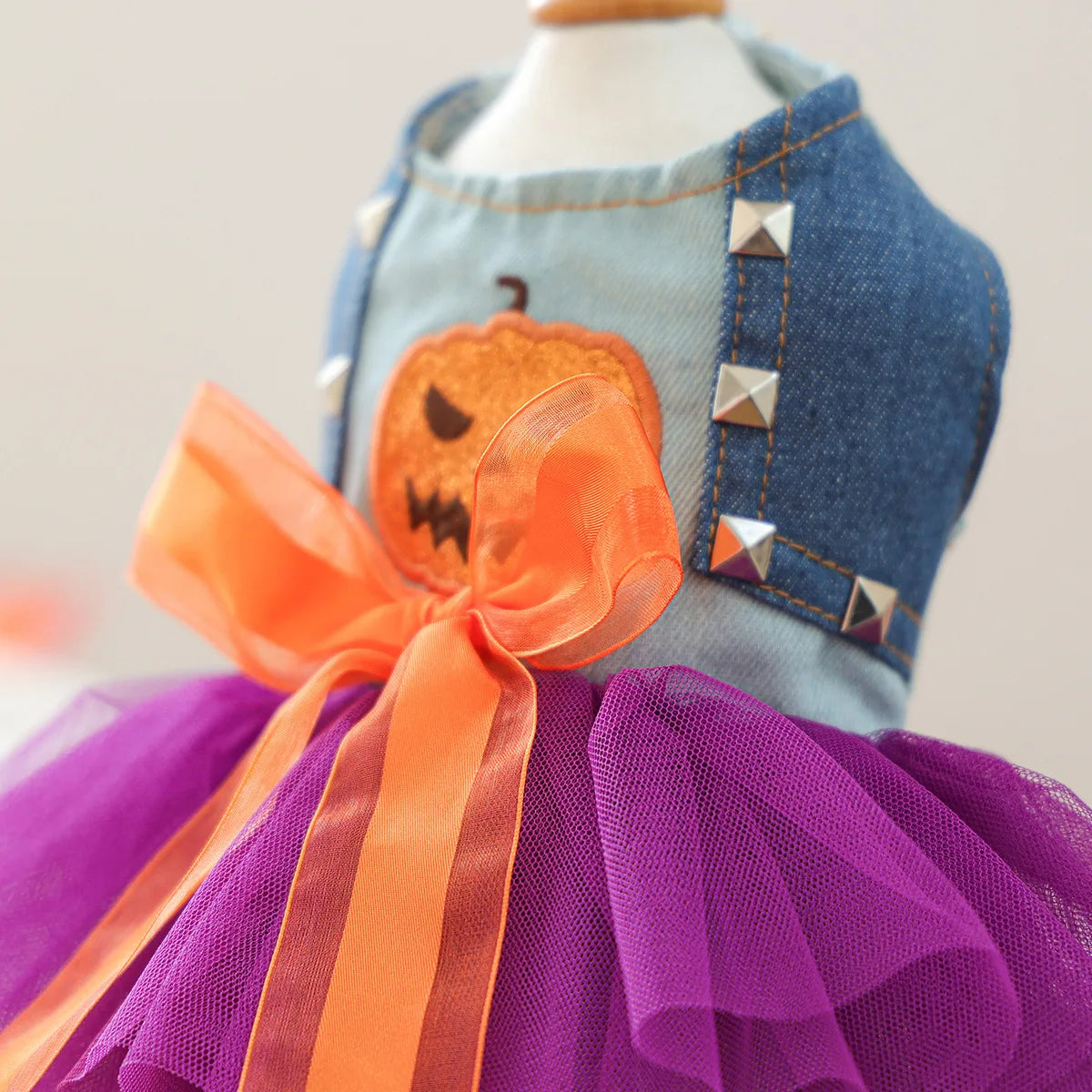 Cute Halloween pumpkin skirt for pets with denim top and vibrant tulle layers in purple and orange