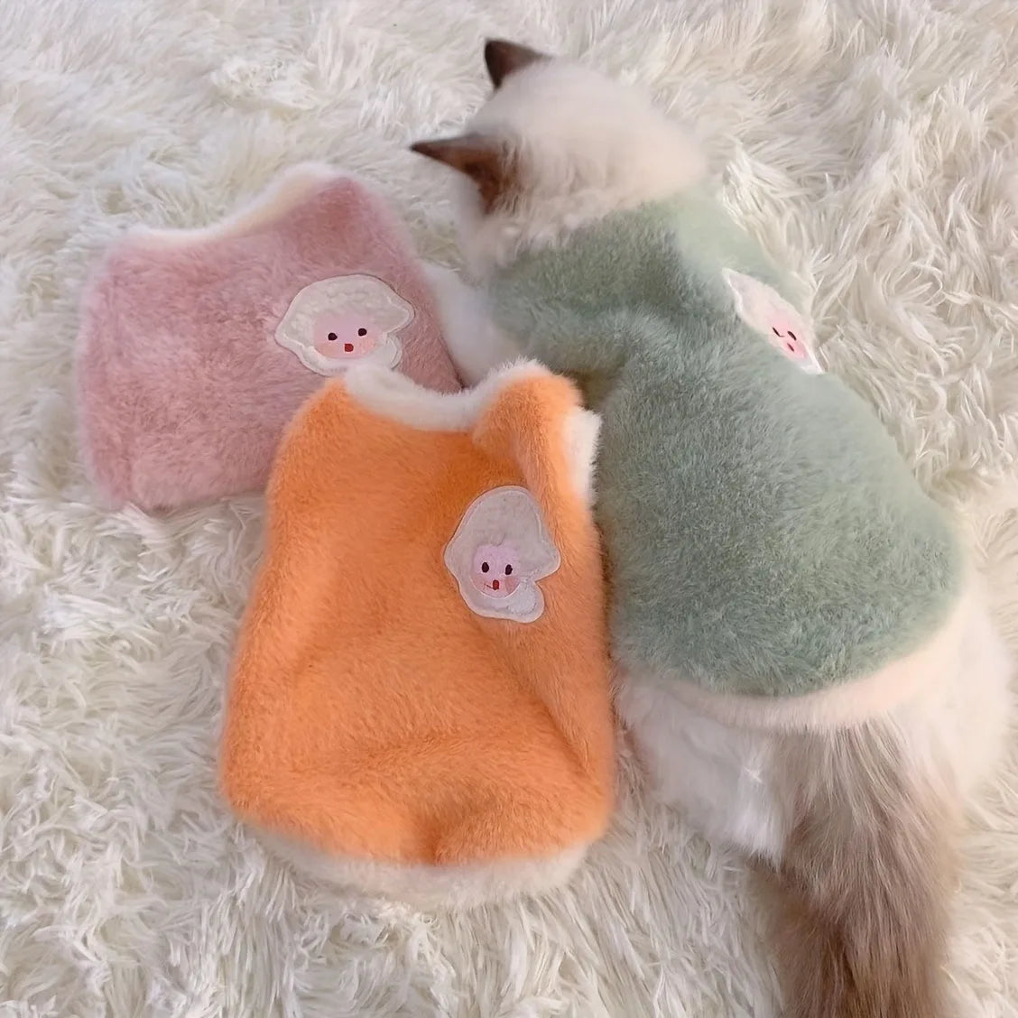 Soft fleece cat vest for winter available in orange, pink, and green colors for cozy feline warmth