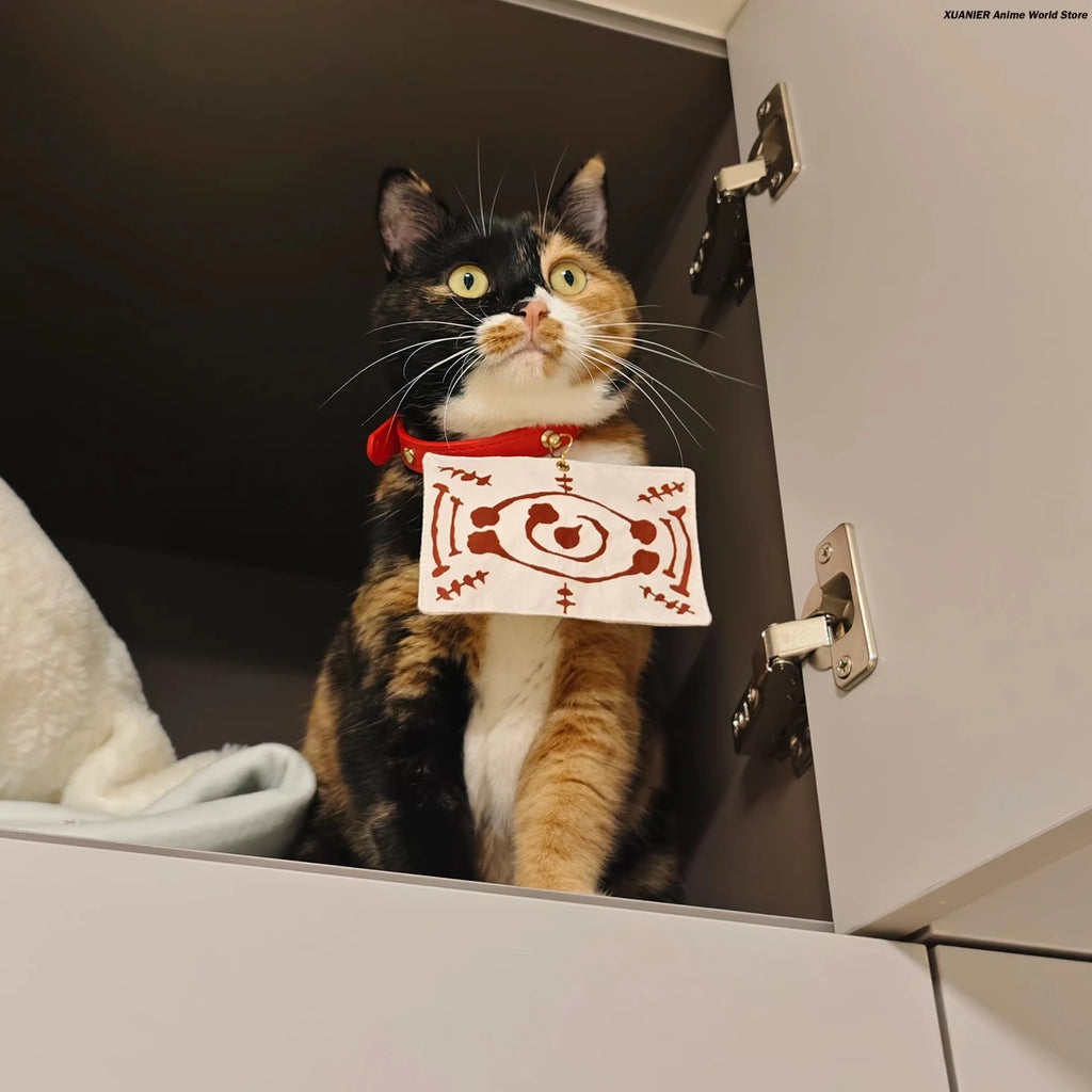 Calico cat wearing an anime cat costume for pets with a red collar and playful expression