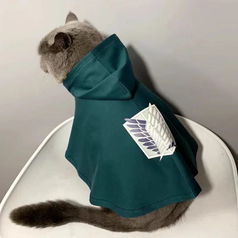 Gray cat wearing Attack on Titan pet cosplay costume with a hood and wing insignia
