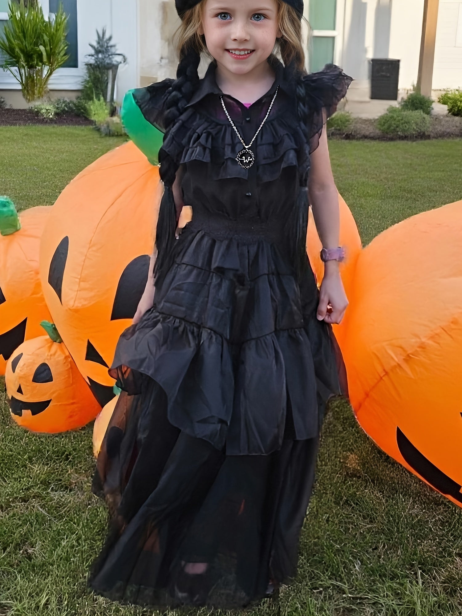 Girl wearing a black princess costume dress for girls with ruffled layers at a Halloween scene