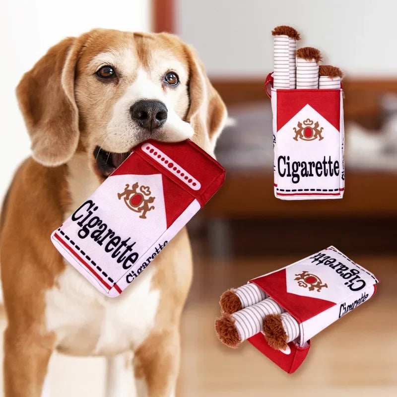 Beagle holding Cheeky Cigarette Plush Dog Toy designed for playful pets with soft texture
