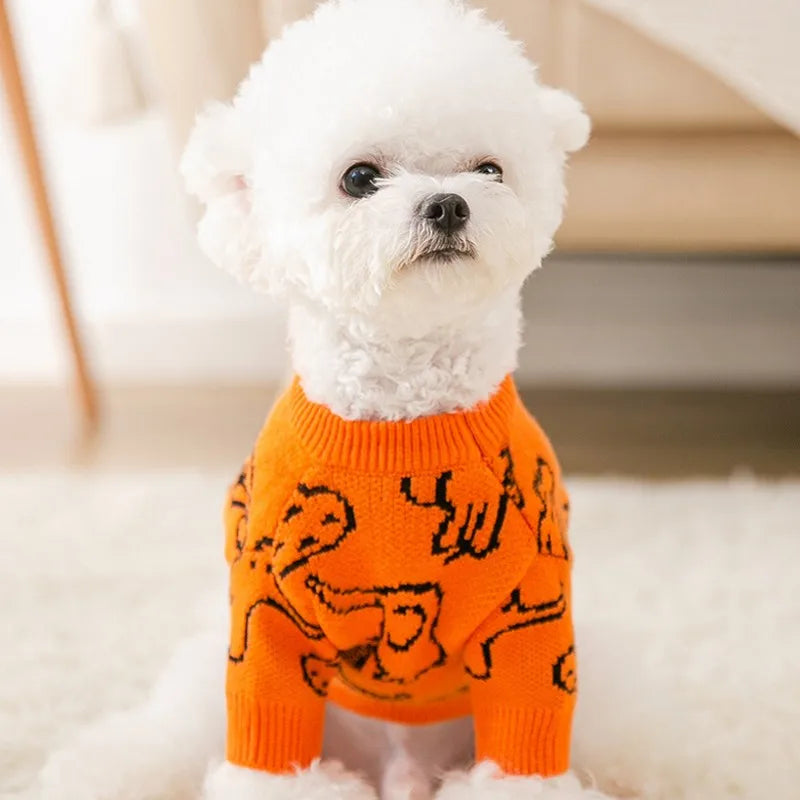 Cute knitted dog coat for winter in orange with playful dog pattern for stylish pet warmth