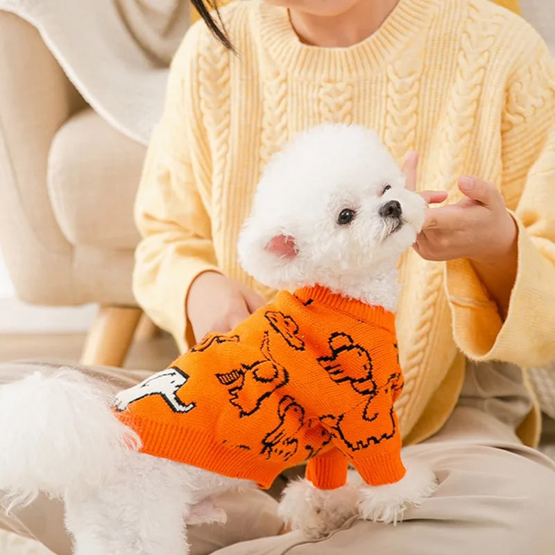 Cute knitted dog coat for winter in orange with playful design, perfect for small dogs