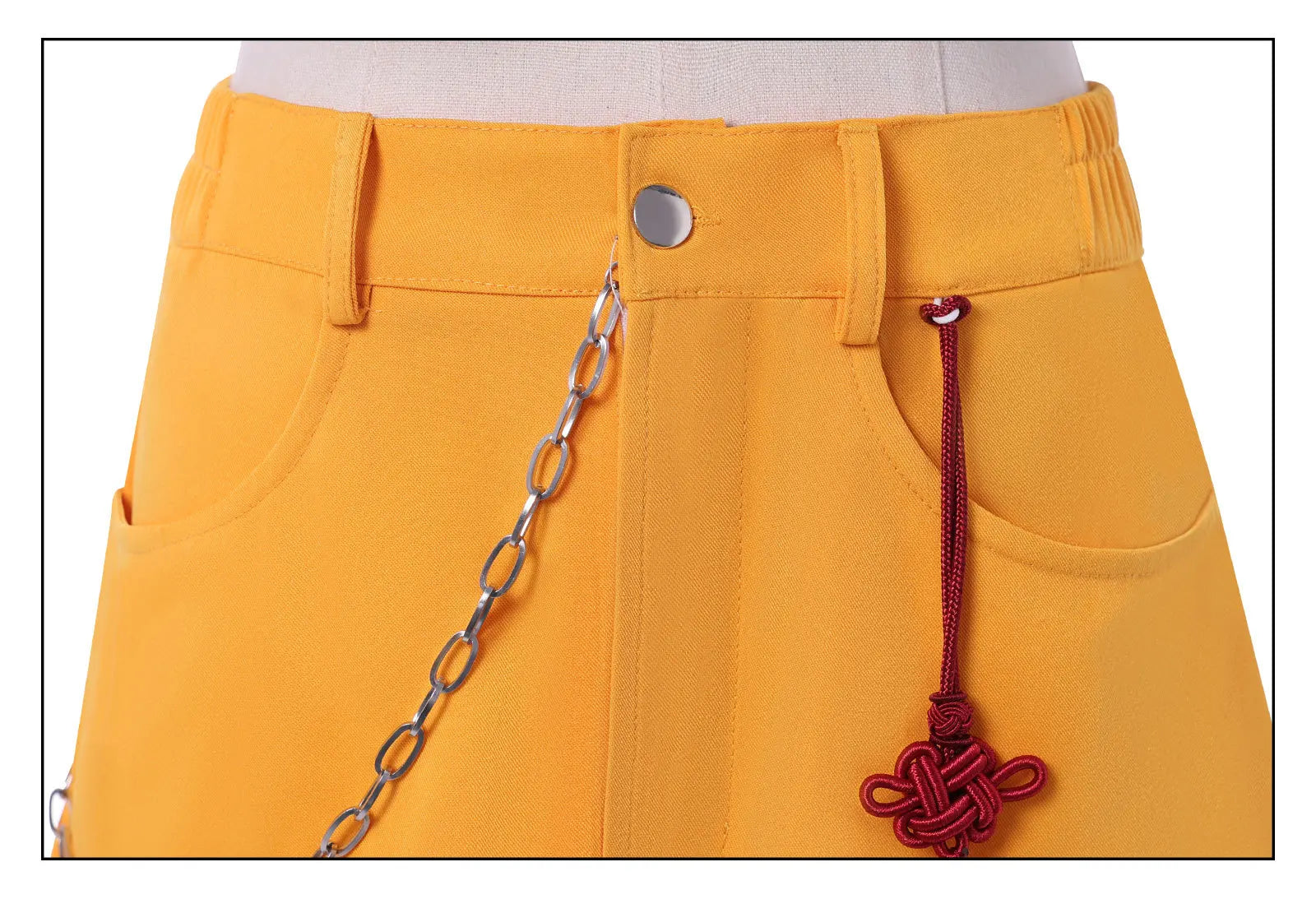 Close-up of yellow skirt detail from Demon Hunter Superstar costume for women featuring chain and charm