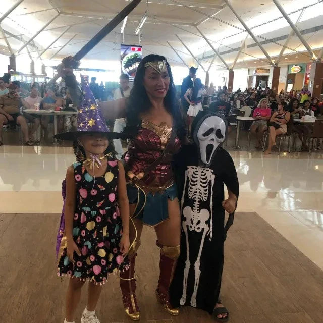 Diana cosplay costume for women modeled by an adult with children in costume at a busy event