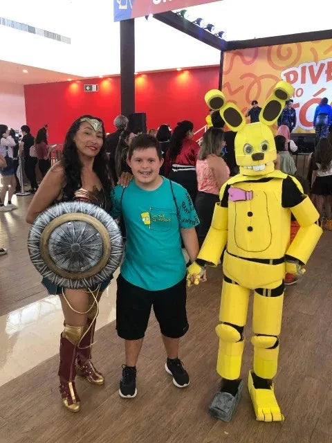 Diana cosplay costume for women with a shield and a young boy in a blue shirt at a convention