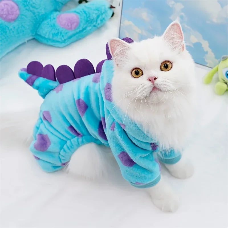 Fluffy white cat wearing a dinosaur dog costume hoodie in blue with purple spikes