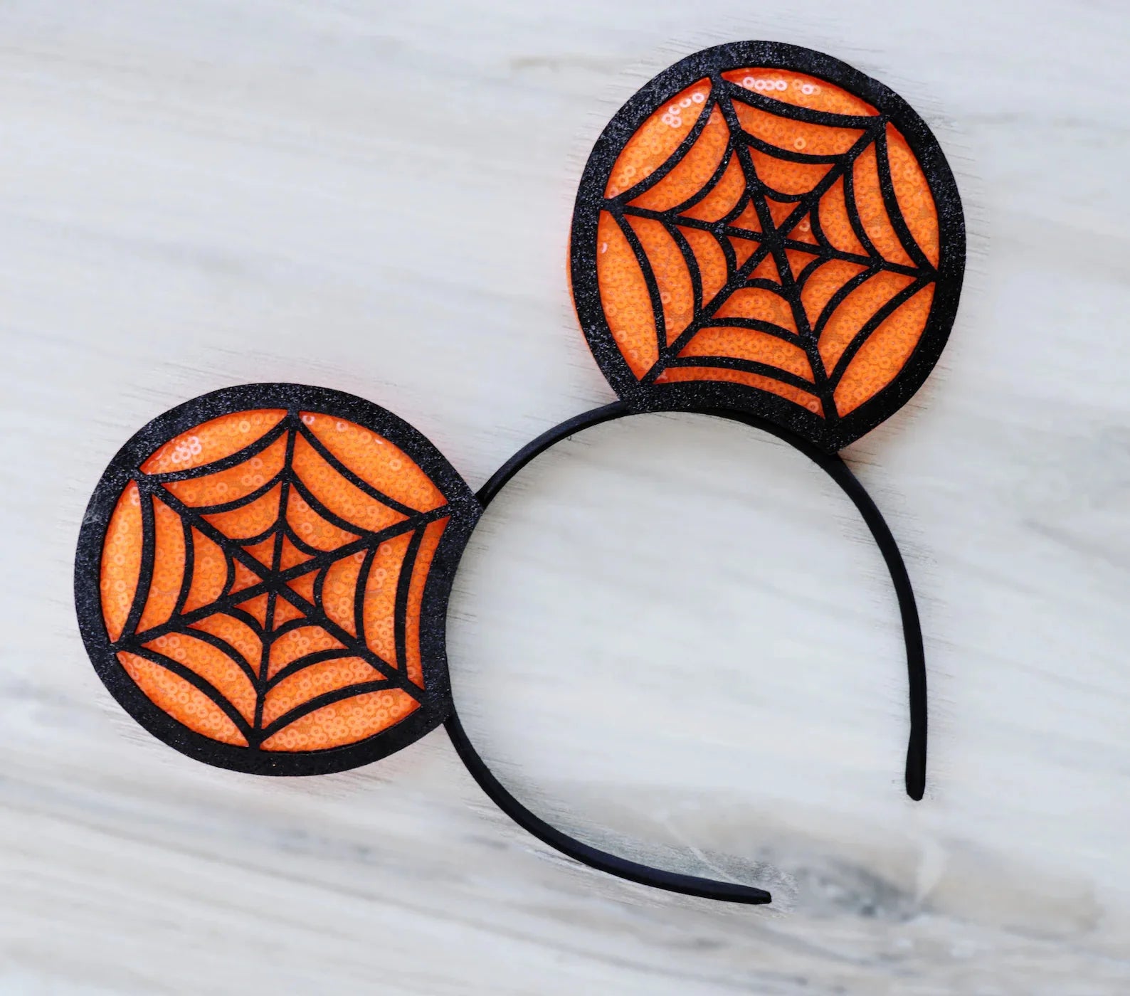 Disney Halloween ear headband featuring orange spiderweb designs perfect for festive celebrations