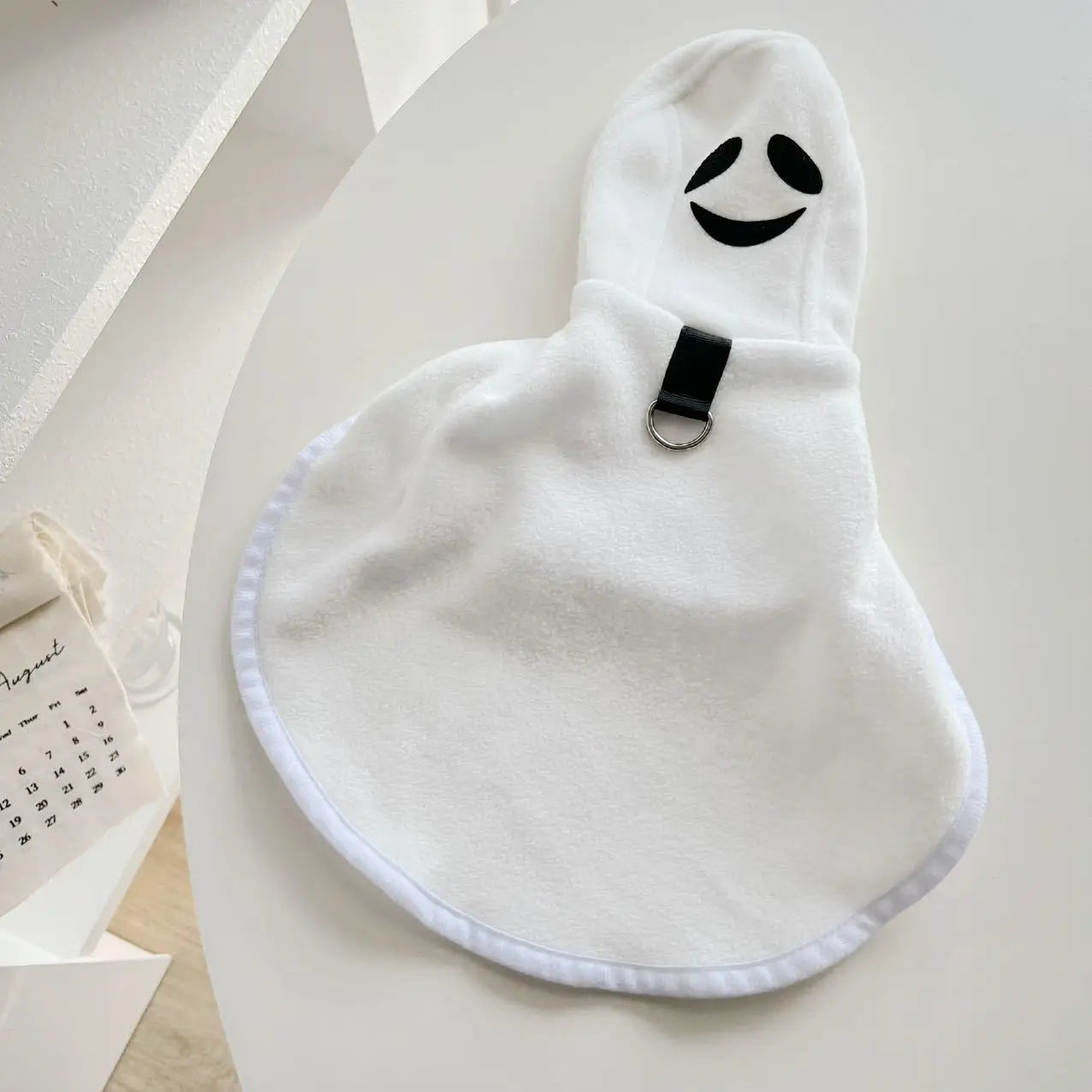 Dog Halloween ghost cape in white with a smiling face design for festive pet costumes