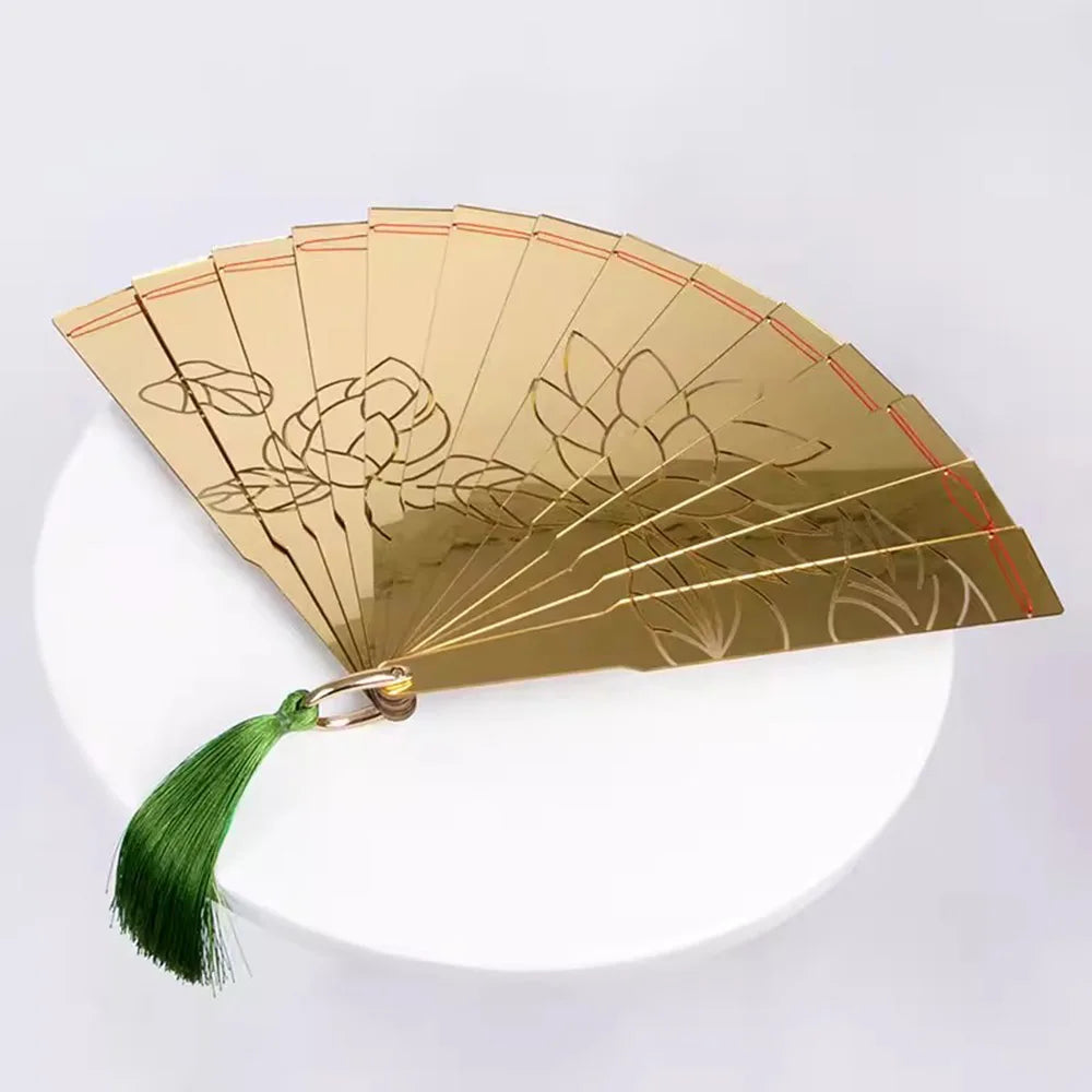 Golden Douma cosplay folding fan with intricate flower engravings and a green tassel