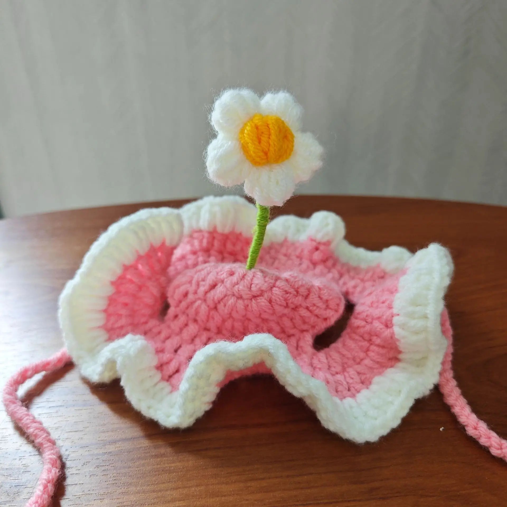 Handmade pink and white crochet pet hat with a flower, perfect for funny pet hats for cats and dogs