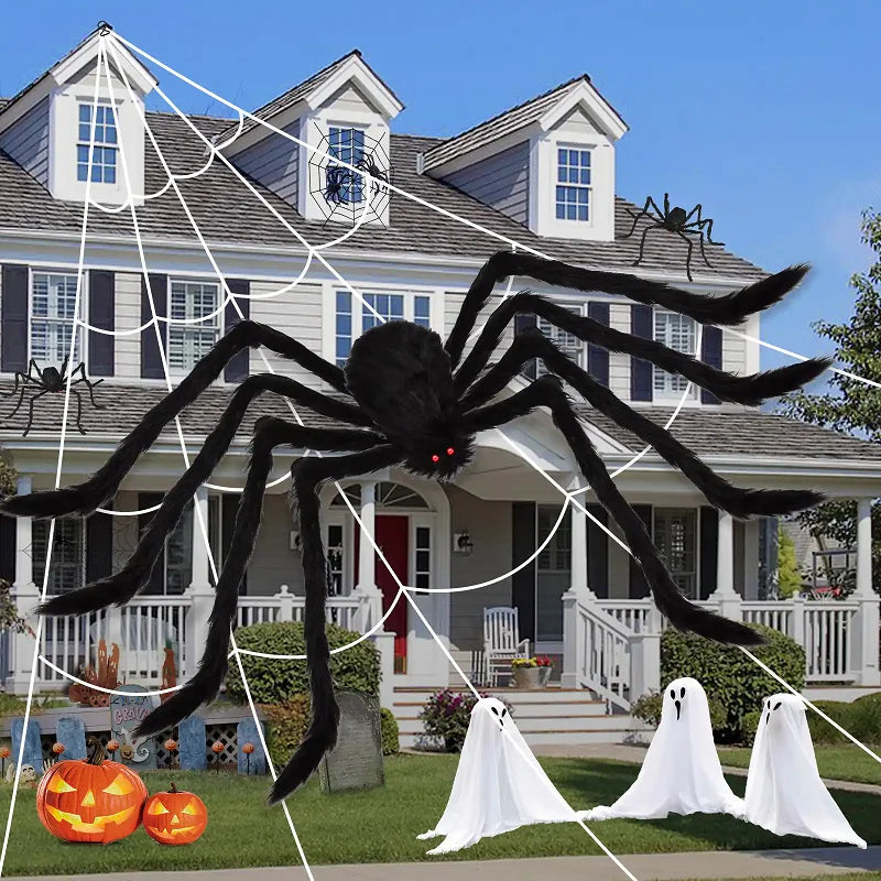 Giant Halloween spider decoration displayed on a house with webs, pumpkins, and ghost figures