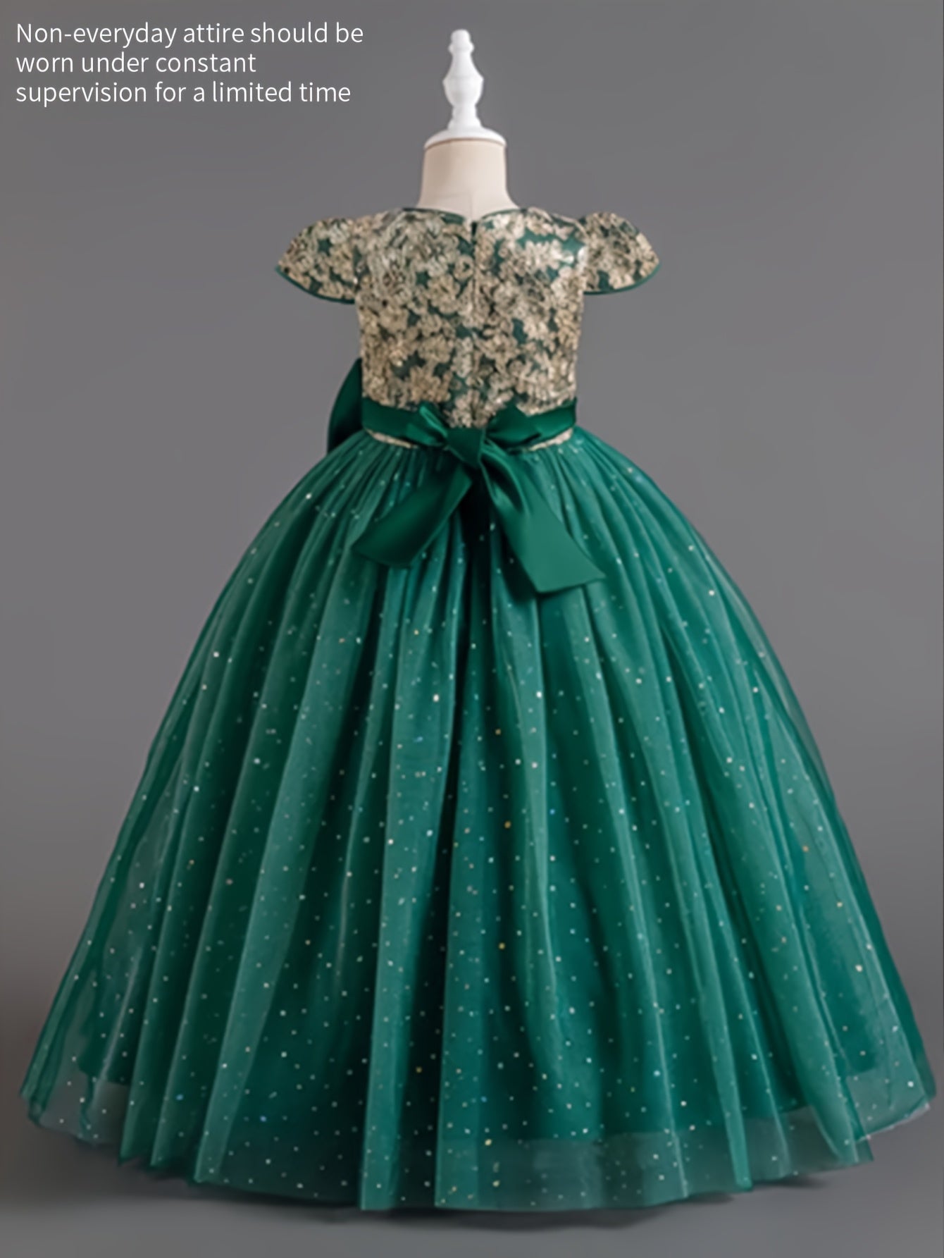 Girls floral wedding dress featuring a floral bodice and a flowing green skirt with sparkles