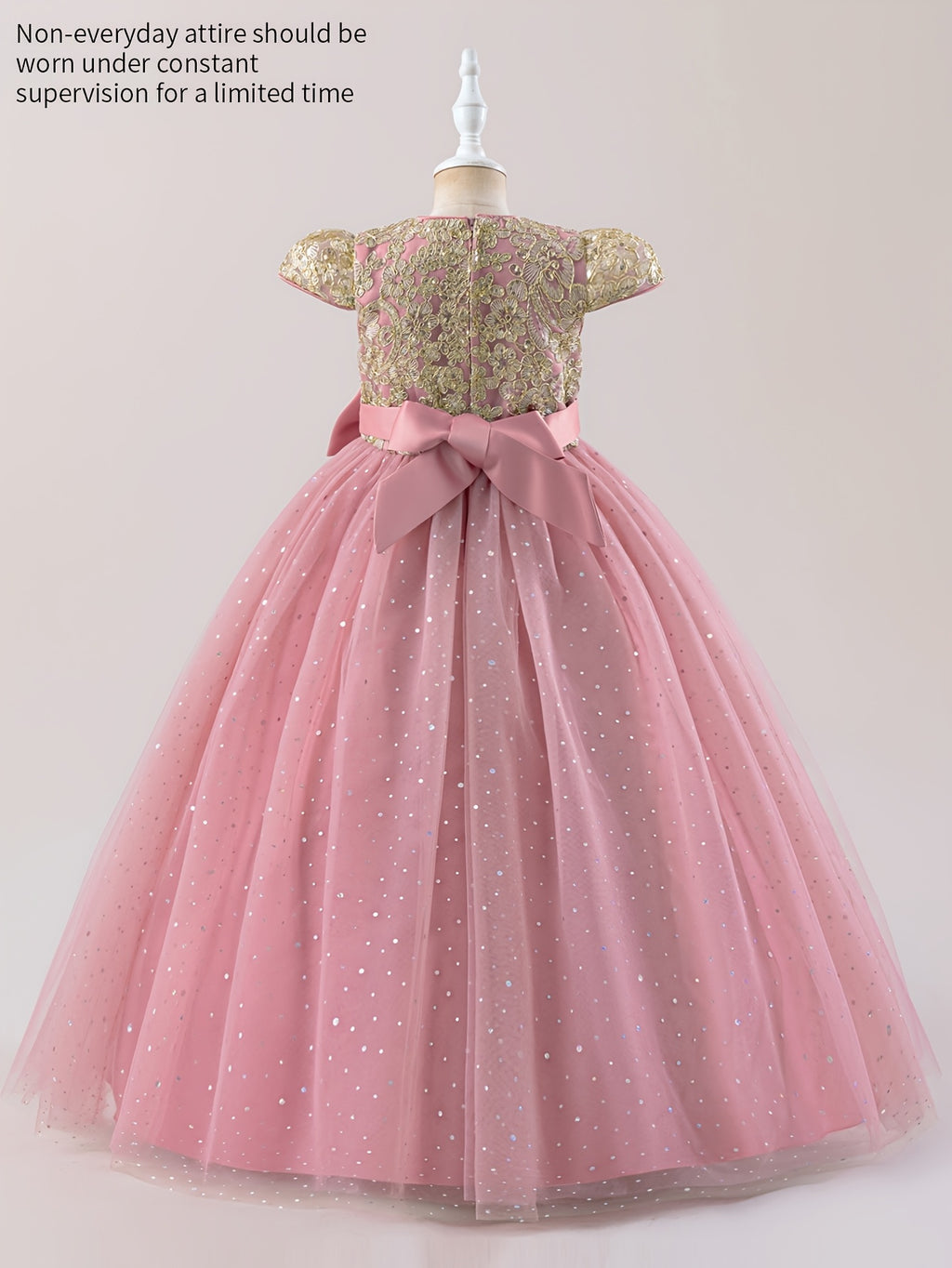 Girls floral wedding dress with a gold bodice and pink tulle skirt, featuring a large bow at the back