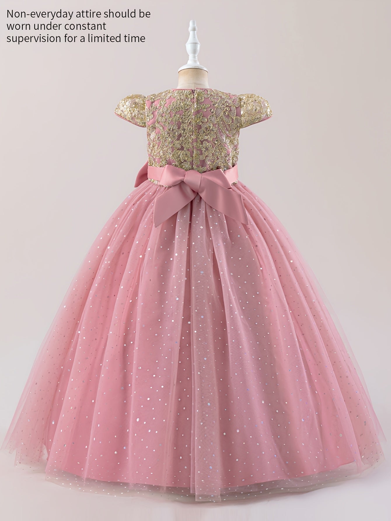 Girls floral wedding dress with a gold bodice and pink tulle skirt, featuring a large bow at the back