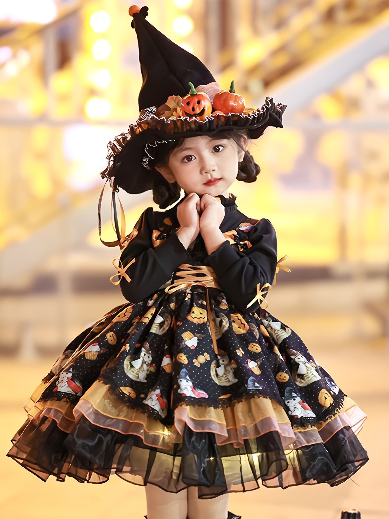 Adorable girls Halloween party dress with pumpkin motifs and a witch hat for festive celebrations