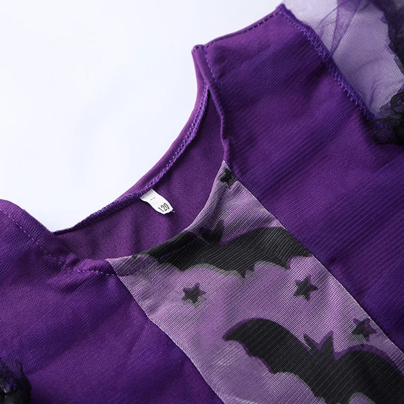 Close-up of girls purple bat costume featuring bat patterns on soft fabric for Halloween celebrations