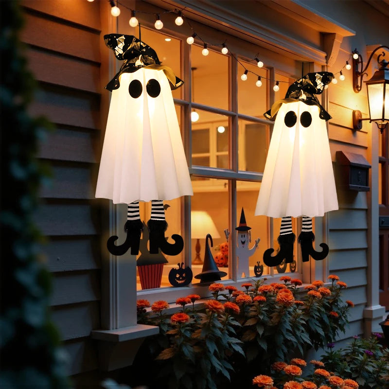 Halloween LED witch ghost decorations hanging on a window with festive lighting and bright flowers