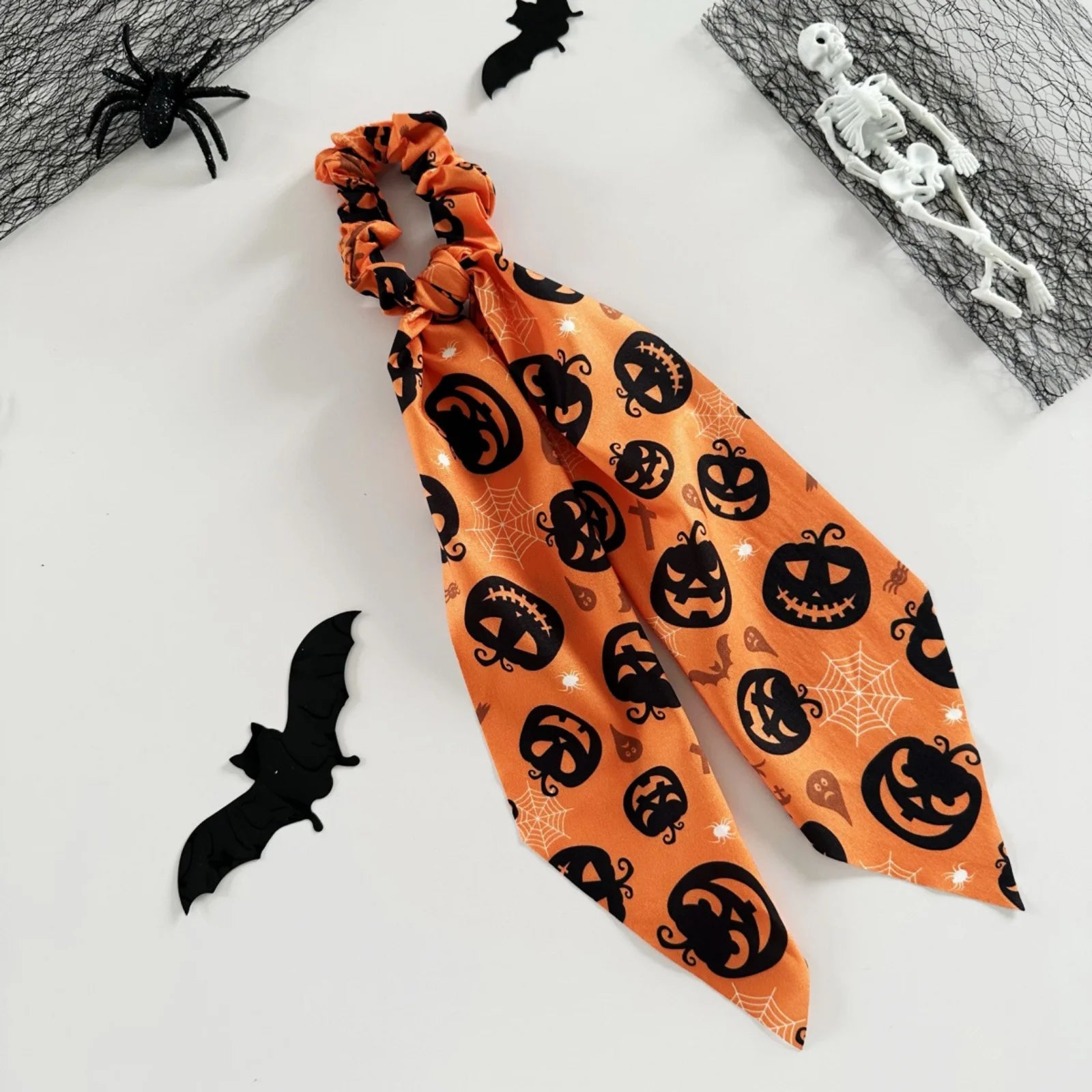 Halloween scrunchies set featuring orange fabric with black spooky patterns for festive hairstyles