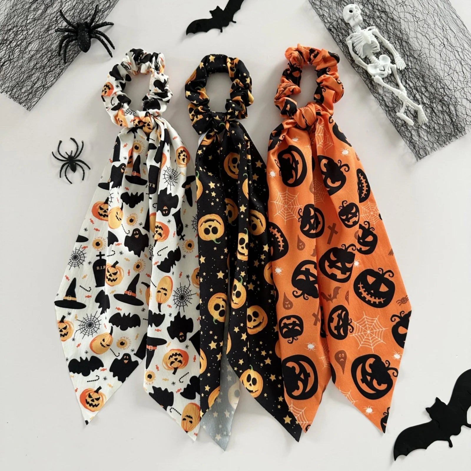 Halloween scrunchies set featuring spooky patterns in orange, black, and white for festive hair styling