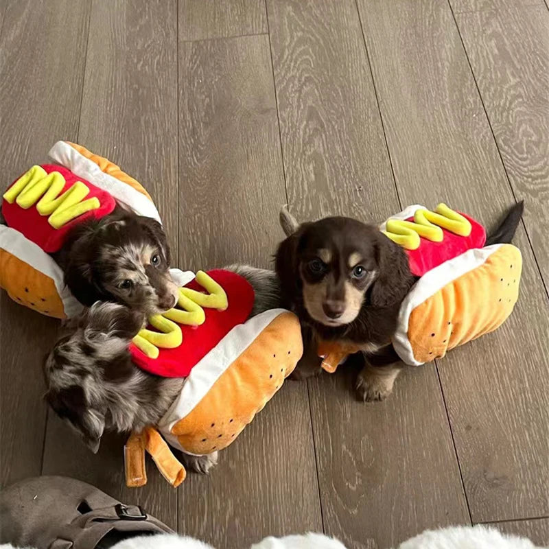 Three adorable puppies wearing hot dog dog costumes with mustard and ketchup details