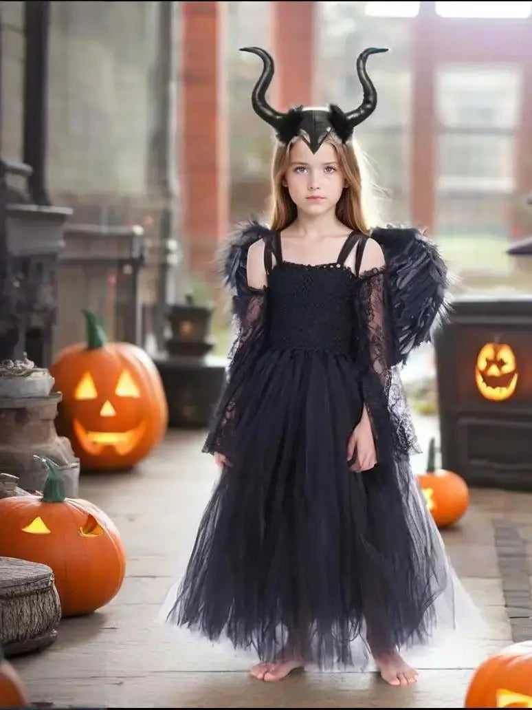 Girl in Maleficent Halloween costume for girls with black wings and horned headpiece in a spooky setting