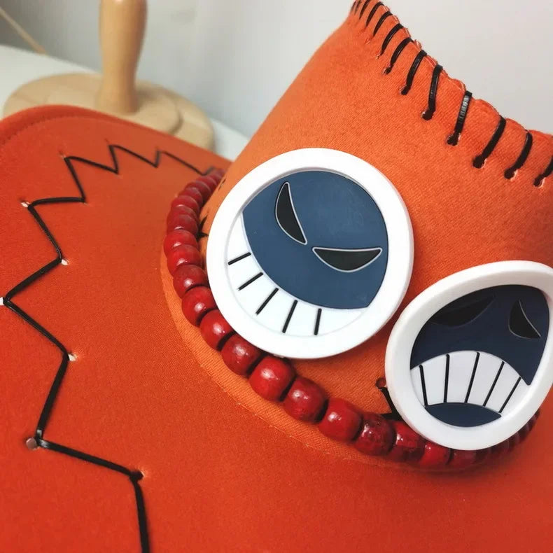 Close-up of Ace cosplay hat One Piece with character badges and red bead decoration