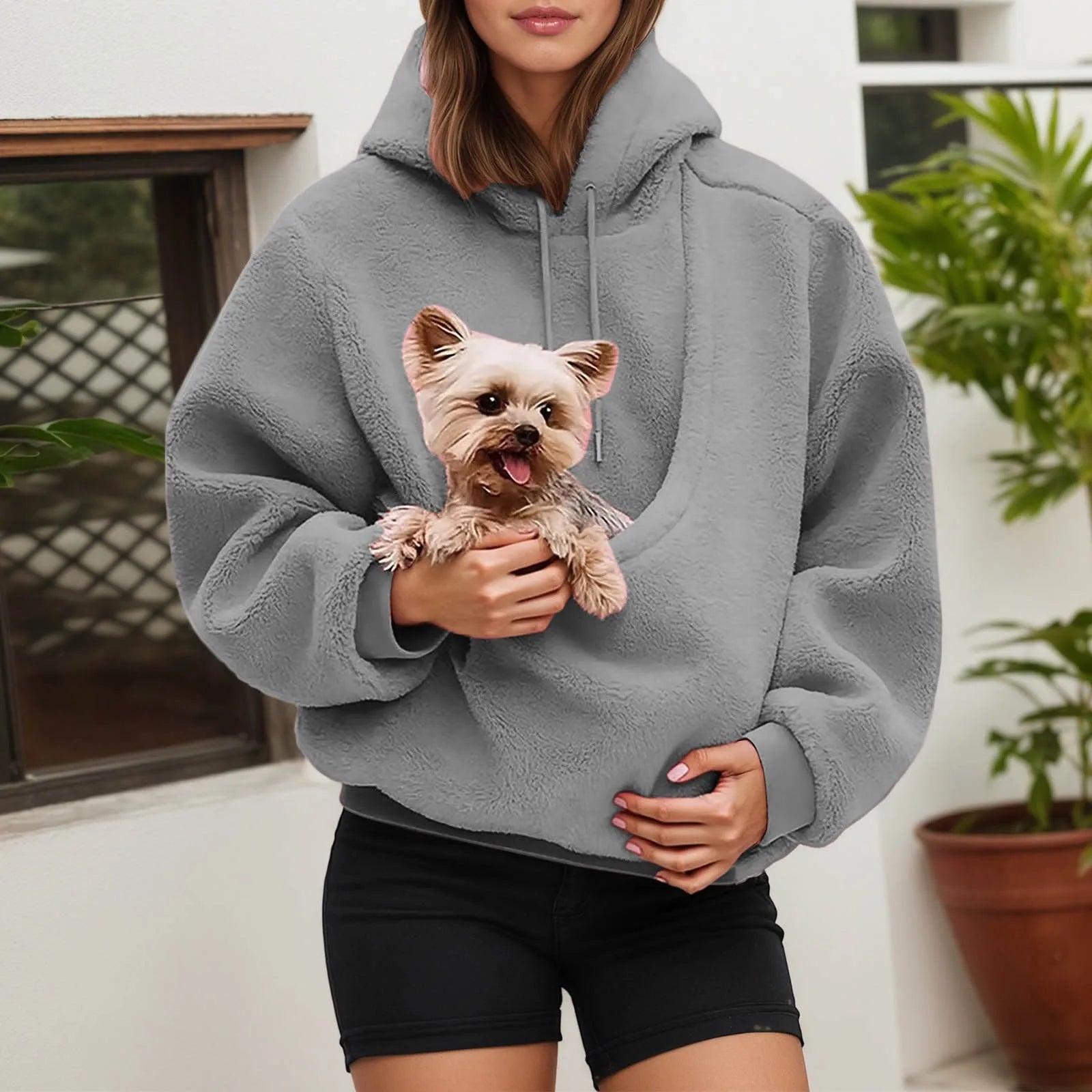 Cozy gray pet carrier hoodie with a pouch holding a small dog for fashionable pet owners