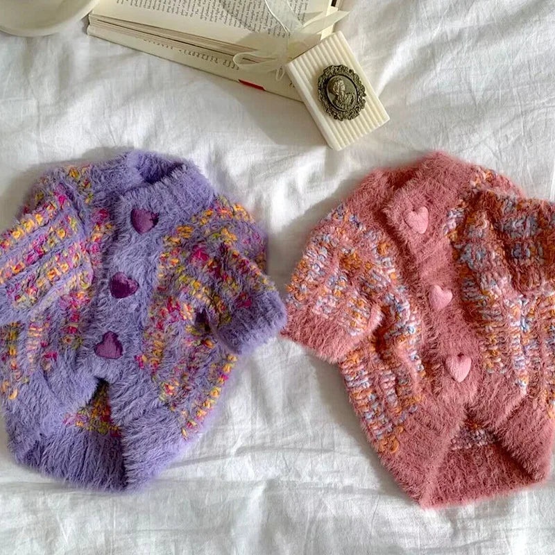 Two puppy knitted coats for winter in purple and pink, featuring heart-shaped buttons and cozy textures