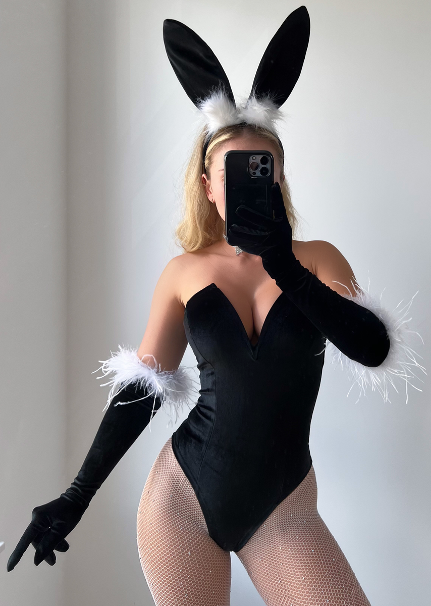 Sexy bunny Halloween costume with black bodysuit, bunny ears, and feather accents